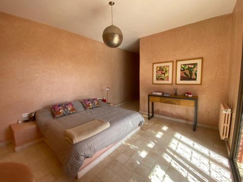 a bedroom with a large bed and a table at Kasbah Oum Rabia in Boulaouane