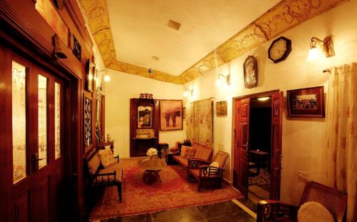 a living room with a couch and a table at The Red House in Ooty