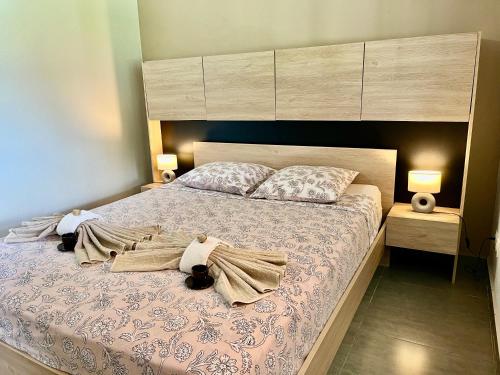 a bedroom with a large bed with two towels on it at Grande villa moderne, calme, piscine & jardin in Le Gosier