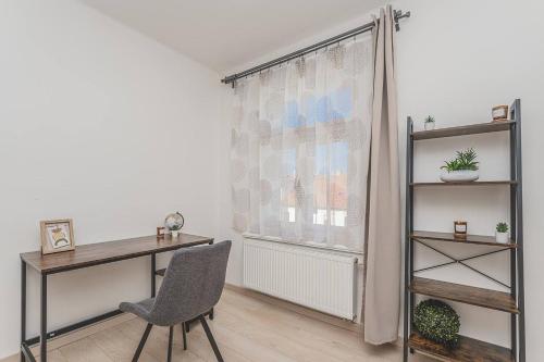 a desk and a chair in a room with a window at 1BD Apartment on Masarykovo Square - Bathtube, Desk & Chair, Free Wi-Fi in Hradec Králové