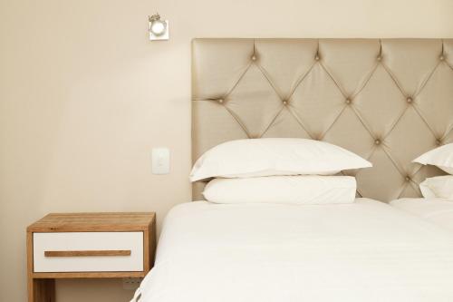 a bedroom with two beds and a headboard at Loerie Guest Lodge in George