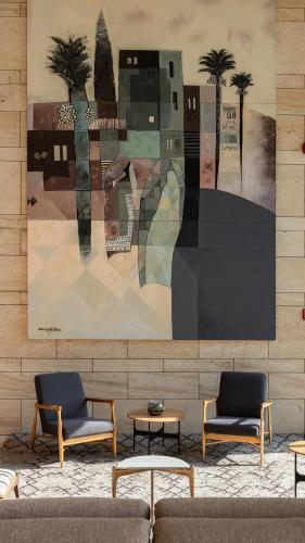 a room with two chairs and a painting on the wall at SHIRVAN Hotel City Yard Jeddah in Jeddah