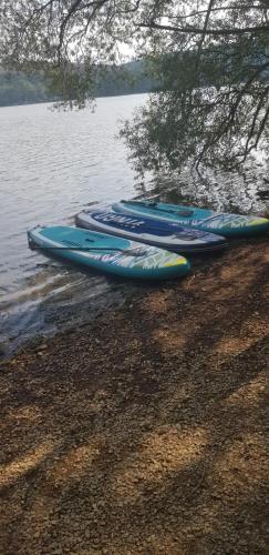 four kayaks lined up on the shore of a lake at Ferienhaus Möhnetal in Allagen