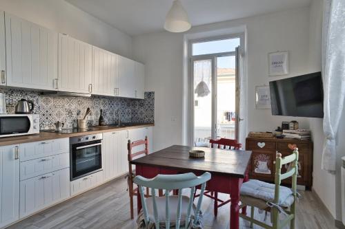 una cucina con un tavolo di legno e una sala da pranzo di Via Puccini 217 a Viareggio
