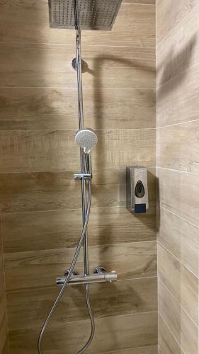 サラエボにあるAAvenue Homeの木製の床の隣にある浴室のシャワー