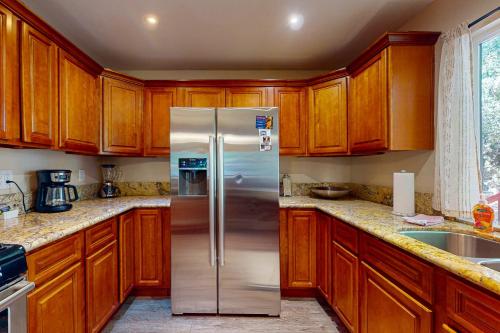 a kitchen with wooden cabinets and a stainless steel refrigerator at Casa Tahquitz in Idyllwild