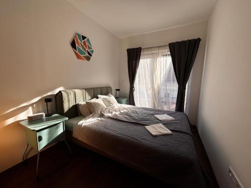 a small bedroom with a bed and a window at Lime Apartment Zamardi in Zamárdi