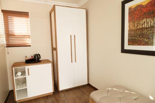 a white refrigerator in a room with a chair at Loerie Guest Lodge in George