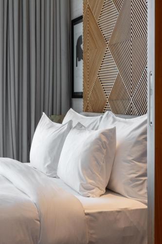 a white bed with white pillows on it at SHIRVAN Hotel City Yard Jeddah in Jeddah