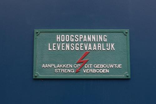 a sign is posted on a blue wall at Bed & Breakfast De Pol in Doetinchem