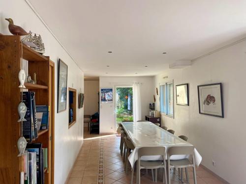 une salle à manger avec une table et des chaises blanches dans l'établissement Family home 150m plage 11 pers, à Saint-Quay-Portrieux