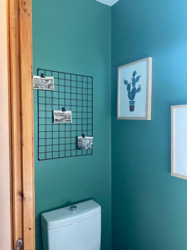 une salle de bain avec toilettes et un mur bleu dans l'établissement Family home 150m plage 11 pers, à Saint-Quay-Portrieux