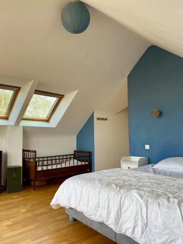 une chambre avec un lit et un mur bleu dans l'établissement Family home 150m plage 11 pers, à Saint-Quay-Portrieux