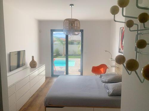 une chambre avec un lit et une vue sur une piscine dans l'établissement Villa Plein Sud, à Villeneuve-de-la-Raho