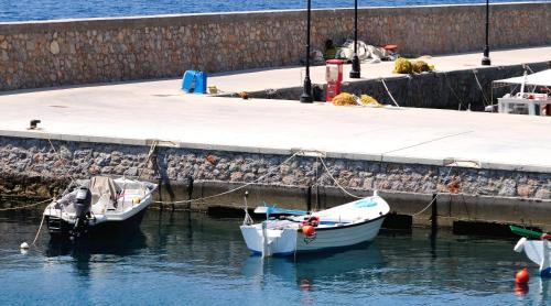 two boats in the water next to a dock at Pharos Rooms in Ilia