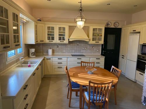 a kitchen with a wooden table and chairs at HOUSE MINA Corfu in Ýpsos