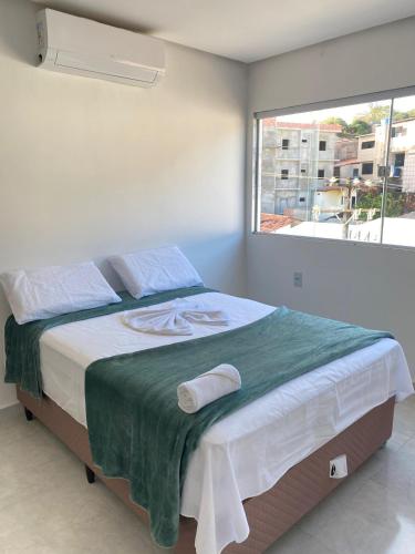 a bedroom with a large bed with a window at Suítes Central Casal in Maragogi