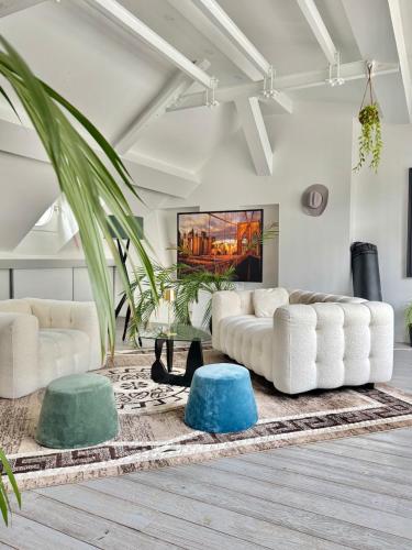 - un salon avec deux canapés blancs et un tapis dans l'établissement Charmant Parisien, à Paris