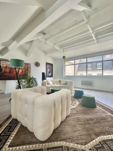 un salon avec un canapé blanc et une table dans l'établissement Charmant Parisien, à Paris