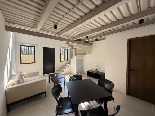 a living room with a table and chairs and a couch at Homa Lofts in Colima