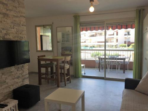 un salon avec un canapé, une télévision et une table dans l'établissement Magnifique Studio cannes, à Cannes