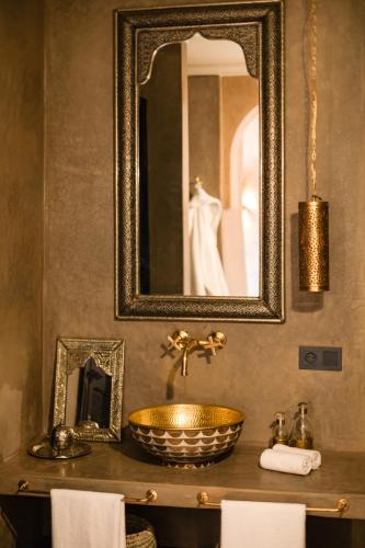 a bathroom with a gold sink and a mirror at Riad Dar Acsameda & Spa in Marrakech