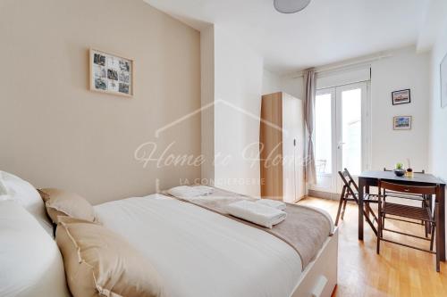 une chambre avec un lit, une table et une fenêtre dans l'établissement Charmant appartement 23m2 à Pantin, à Pantin