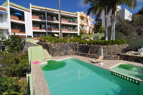 a swimming pool in front of a building at Apartamentos Atlantis in Tazacorte