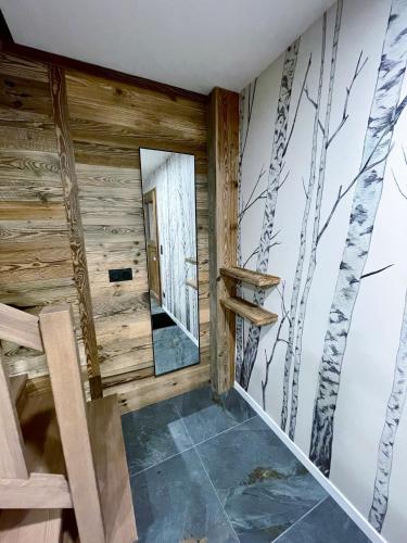 Cette chambre est dotée d'un mur en bois avec un miroir. dans l'établissement Chalet l'Alisier - Modern chalet, beautiful mountain view, Morzine-Les Gets, à La Côte dʼArbroz