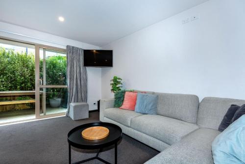 a living room with a couch and a table at Urban Oasis Central Christchurch - parking in Christchurch