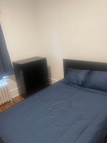 a bedroom with a blue bed and a dresser at Banlieue Pillars Maison in Mount Vernon
