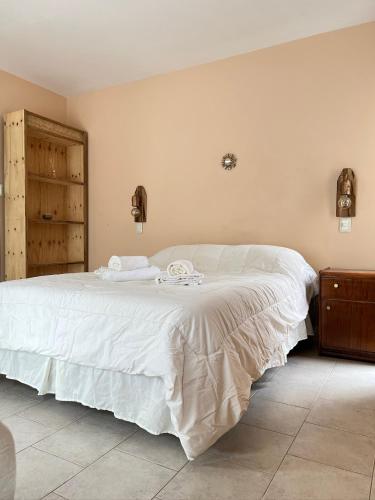 Un dormitorio con una cama grande con sábanas blancas. en Mi Universo, en Villa Cura Brochero