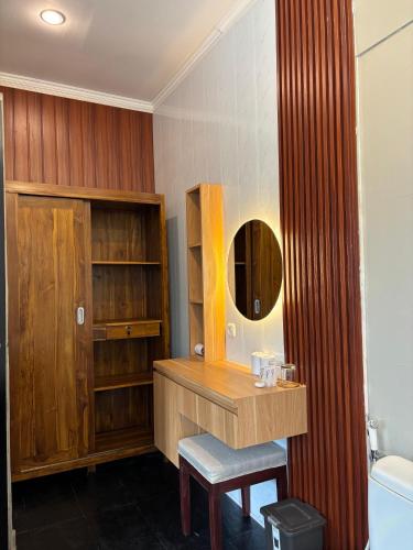 a bathroom with a wooden vanity and a mirror at Igna Bungalows in Ubud