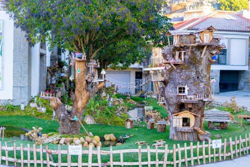 a tree stump with a house in it at Casa Luna Rural Con Piscina y Jardín in Ourense