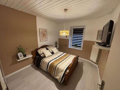 une chambre avec un lit et une télévision à écran plat dans l'établissement Green Cottage, 3 chambres, 7 voyageurs, à Rouhling
