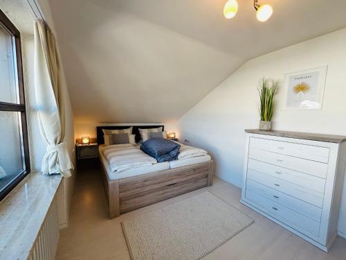a bedroom with a bed with a blue pillow on it at BerglerNest - Apartment mit Bergblick! in Bihlerdorf
