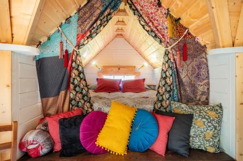 a room with a bed with colorful pillows at Ophrys ha Melenig in Plouhinec