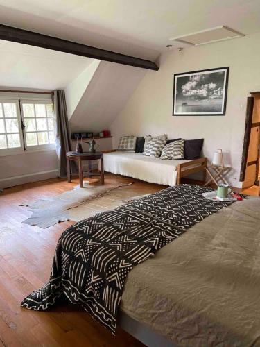une chambre avec un grand lit et une table dans l'établissement Maison dans le Perche type cottage, à Saint-Agnan-sur-Sarthe