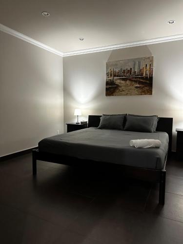 a bedroom with a bed with a painting on the wall at Luxury Vancouver Suite Near YVR and Downtown in Vancouver