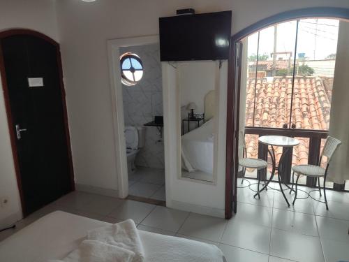 a bathroom with a tub and a toilet and a table at Pousada L'étage in Búzios