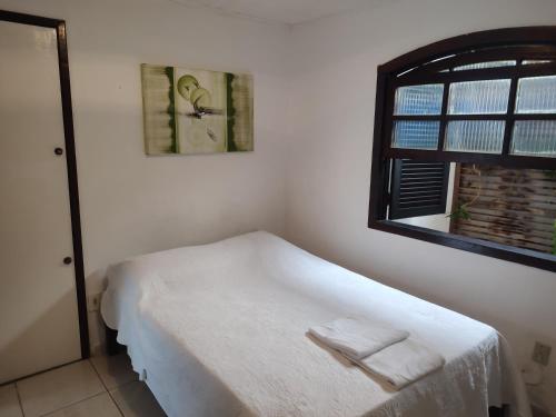 a bedroom with a bed with two towels on it at Pousada L'étage in Búzios