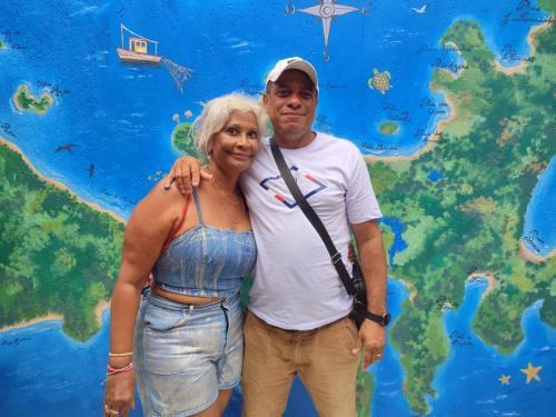a man and a woman standing in front of a map at Pousada L'étage in Búzios