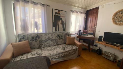a living room with a couch and a tv at Refúgio dos Mauzinhos in Ourondo