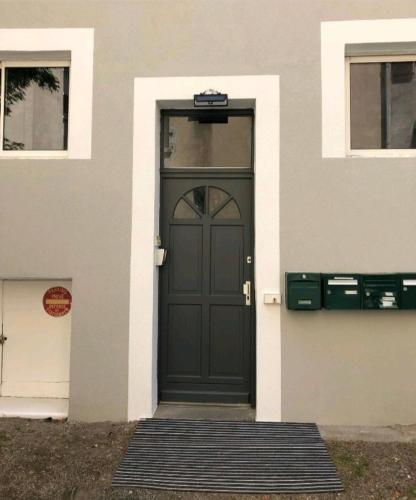 une porte noire sur le côté d'un bâtiment dans l'établissement F2 centre ville de Vichy, à Vichy