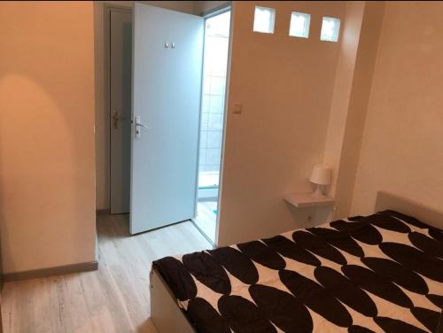 - une chambre avec un lit noir et blanc et une porte dans l'établissement F2 centre ville de Vichy, à Vichy