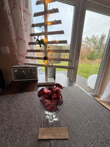 a glass bowl of roses sitting on top of a table at Ślusarnia-domek z sauną i balią nad jeziorem, Kaszuby in Żuromino