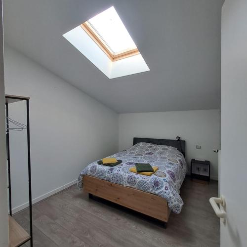 une chambre avec un lit et une lucarne dans l'établissement Le Beltremieux, à La Rochelle