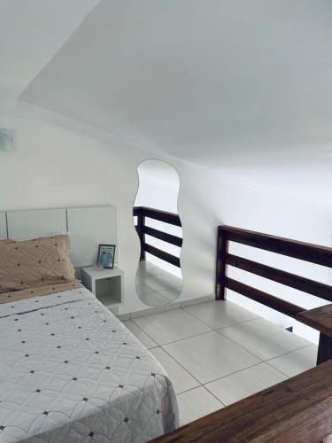 a bedroom with a bed and a chair at Lofts Inverno Centro Histórico in Paraty