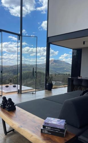 a living room with a table and a view of the mountains at Casa Vilas Boas Macacos in Nova Lima
