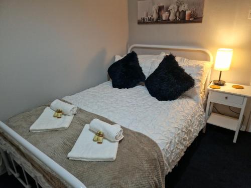 a bedroom with a bed with towels on it at Markfield Maison in Markfield